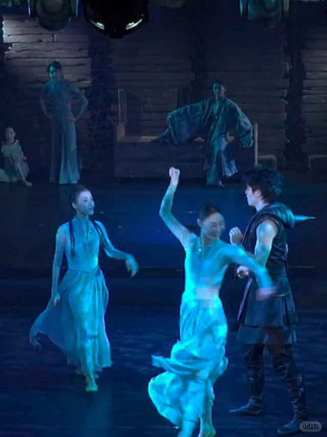 Da Wo Xian Ren dancers performing together under blue stage light